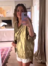 Camisa dorada metalizada de lino, corte holgado, con tajos laterales y espalda más larga.