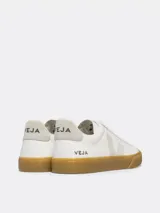 Championes Veja modelo Campo, de diseño minimalista en color blanco con detalles en gris claro. Presentan el logo lateral en forma de V, suela de goma color caramelo y cierre mediante cordones.