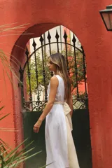 Vestido midi blanco y beige con escote en V, sin mangas y cinturón con hebilla de nácar.