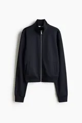 Campera deportiva corta de punto grueso con leve brillo, cuello elevado, cierre frontal y bolsillos laterales insertados.
