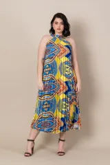 Vestido midi de satén estampado con motivos étnicos en tonos amarillo, azul y rojo. Diseño suelto, plisado y con cuello halter.