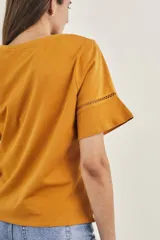 Remera celeste de algodón peinado, con cuello redondo y mangas cortas con detalle de calado.