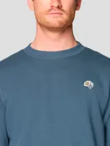 Buzo de cuello redondo en color azul, confeccionado en mezcla de algodón. Presenta un diseño liso con puños y bajo acanalados, y cuenta con un pequeño logotipo bordado en el pecho.