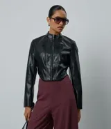 Campera corta estilo corset confeccionada en poliuretano, con cuello alto, cierre frontal por cremallera, mangas largas y ruedo redondeado. Presenta recortes que definen la silueta.