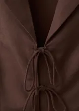 Camisa sin mangas de diseño recto en tejido mezcla de algodón, viscosa y lino, con cuello en V y cierre frontal con múltiples lazos para atar.