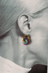 Aros tipo argolla dorados con dije circular esmaltado en colores rojo, azul, verde y blanco, con un patrón floral.