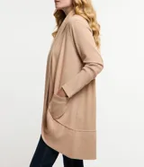 Cardigan largo de punto color beige, con frente abierto, mangas largas y bolsillos laterales. Diseño básico y versátil de corte holgado.