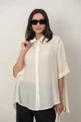 Camisa oversize de seda negra, con cuello camisero, cierre frontal con botones y mangas cortas con vuelta.