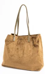 Bolso tipo tote de gran tamaño confeccionado en material sintético con acabado efecto gamuza en color tostado. Presenta doble asa larga en tono contrastante y placa metálica pequeña con logo de la marca en la parte frontal.
