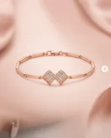 Pulsera de plata con baño de oro rose, con diseño rígido articulado y detalles centrales decorados con circnias pavé.