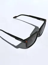 Lentes de sol de diseño cuadrado con marco negro mate y detalles en color naranja. Cuentan con cristales oscuros polarizados con protección UV 400.