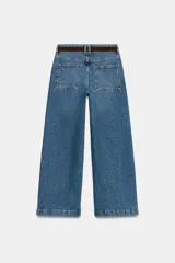 Jeans blancos wide leg cropped de tiro alto, con diseño de cinco bolsillos y pernera ancha y corta. Incluye un cinturón fino de color marrón oscuro con hebilla metálica y cuenta con cierre frontal de cremallera y botón metálico.