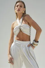 Top halter color gris plateado, con tiras finas que se atan al cuello y espalda descubierta.