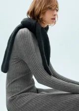 Vestido midi de punto acanalado con cuello perkins y manga larga. Presenta un diseño ajustado en el torso que se abre ligeramente hacia el ruedo en corte evasé.