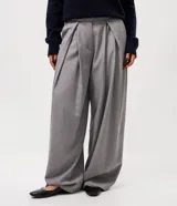 Pantalón de sastrería modelo pantalona, de corte amplio y tiro alto. Presenta pinzas frontales, cierre con cremallera y botón, y presillas en la cintura. Incluye un cinturón ajustable del mismo tejido.