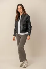 Campera de cuero color negro, de corte clásico y diseño estructurado, con costuras a contratono, bolsillos frontales con solapa, detalles bordados y cierre frontal de botones metálicos.