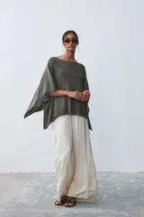 Poncho tejido de color verde militar, con cuello bote y corte holgado.