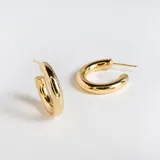 Par de aros tipo argolla abiertos, color dorado, con diseño inflado y lisos.