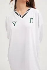 Camiseta blanca oversize de manga larga con cuello en V y número 17 estampado en el pecho.