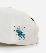 Gorra blanca de algodón con visera curva, estilo dad hat, con ajuste trasero de hebilla y bordados de personajes de Los Pitufos.