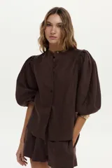 Camisa de lino blanca con mangas abullonadas y diseño para anudar al frente.