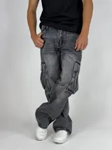 Pantalón de jean gris oscuro lavado, estilo cargo y corte baggy, con múltiples bolsillos laterales y calce holgado.