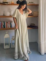 Vestido largo color crema de algodón con mangas cortas amplias, escote en V y estampado geométrico en el ruedo.