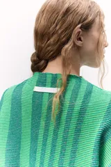 Sweater tejido de punto a rayas texturizado con lurex, color verde y azul. Cuenta con un calce oversize, mangas tres cuartos y cuello bote.