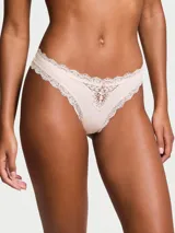 Panty tipo tanga de tiro bajo color rosado, confeccionado en microfibra suave con detalles de encaje y roseta decorativa en la parte frontal.