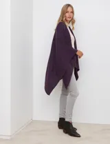 Ruana de tejido soft, color marrón óxido, de corte amplio y sin cierres, con cuello redondo.