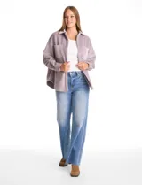 Sobrecamisa de pana con textura acanalada, corte oversize y silueta holgada. Presenta cuello clásico, cierre frontal con botones metálicos, mangas largas con puños abotonados y dos bolsillos frontales tipo parche con solapa.