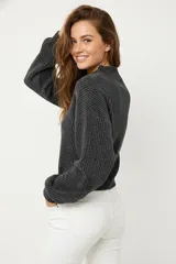 Sweater de tejido de punto grueso, color gris oscuro, con cuello redondo y mangas largas abullonadas.