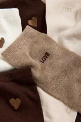 Pack de cinco pares de medias de algodón peinado en tonos degradados, desde marrón oscuro hasta crema. Cada par presenta un detalle bordado diferente, incluyendo corazones y palabras como LOVE y KISS.