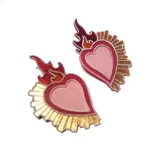 Par de aros con forma de corazón sagrado, con llamas rojas y rayos dorados.