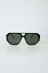 Lentes de sol con armazón de policarbonato negro y cristales tonalidad ámbar, con diseño de puente doble estilo aviador.