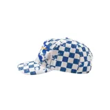 Gorro con visera tipo trucker, con estampado de cuadros estilo damero en azul y blanco, efecto desgastado con salpicaduras y bordado frontal en relieve con letras grandes y un rayo amarillo.