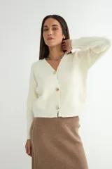 Cardigan negro de tejido de punto, con escote en V, manga larga y cierre frontal con tres botones dorados grandes.