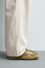 Zapatilla de estilo retro con cordones, confeccionada en una combinación de piezas de tela y cuero con acabado de gamuza. Cuenta con suela dentada en contraste.