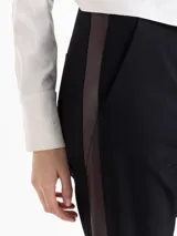 Pantalon sastrero negro con diseño tipo jogger, cuenta con bolsillos delanteros, bolsillos ojal traseros, cinta lateral de cuero y puños tejidos en ribb en el ruedo.