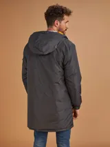 Campera de abrigo azul marino con capucha, cierre frontal con botones y cremallera, múltiples bolsillos y forro interior naranja.