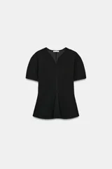 Top peplum negro de manga corta abullonada, con escote en pico y bajo recto con pliegue frontal.