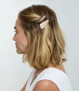 Kit de dos pinzas para el pelo con diseño triangular redondeado, una en tono carey y otra en tono marmolado claro. Fabricadas en resina con mecanismo metálico.