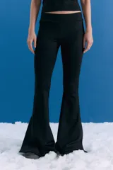 Legging estilo oxford confeccionada en lycra tipo neoprene, con tajo lateral en la botamanga que revela un interior en color azul. Presenta un isologo bordado en el delantero y un calce ajustado que se ensancha hacia el ruedo.