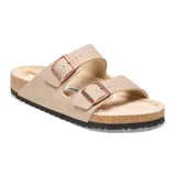 Sandalia Birkenstock modelo Arizona con dos correas ajustables con hebillas metálicas. Presenta un diseño en color beige con interior forrado en piel sintética, plantilla de corcho y suela de goma negra.