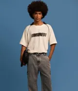 Pantalón de jean modelo baggy con bolsillos cargo laterales, cintura con trabillas y cierre frontal con botón y cremallera.