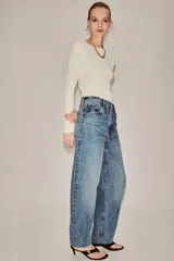 Jeans de tiro alto con corte tapered y largo al tobillo. Presenta cinco bolsillos, trabillas en la cintura, cierre frontal con cremallera y botón, y detalle de raya planchada en el delantero.