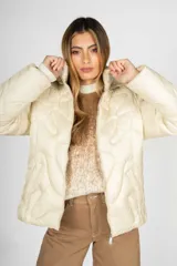 Campera puffer color crudo con diseño acolchado, cierre frontal y capucha. Confeccionada en nylon, presenta un corte moderno y versátil.