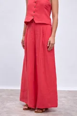 Pantalón palazzo color coral con bolsillos laterales y cintura alta.