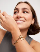 Pulsera dorada elástica con dije de libélula y dije rectangular con la inscripción "Sweet".