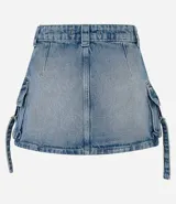 Pollera mini de jean con efecto mármol, diseño de tiro medio con bolsillos cargo laterales, lazos decorativos con hebillas y cierre frontal tradicional.